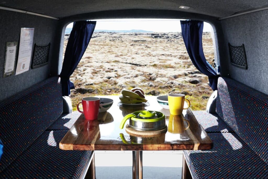 Rear doors of the Easy Clever open onto a mossy landscape, with mugs and a kettle on the wooden table