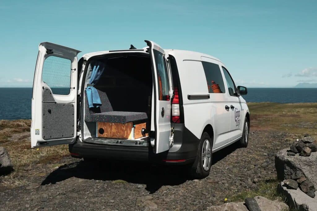 Rear doors of the Easy Small EXP open beside the sea, showing the wooden interior units